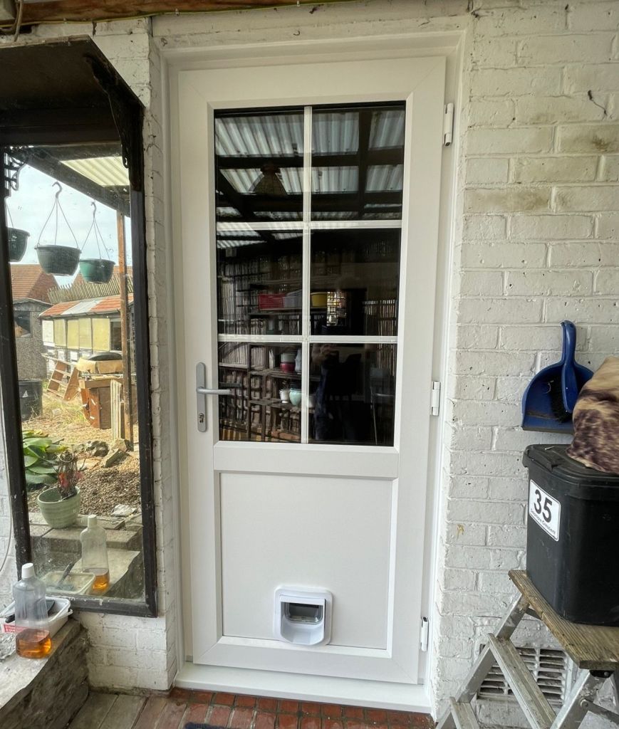 Outside view of a white John Fredericks Plastics PVCu door with Georgian bar top and a cat flap in Croydon.